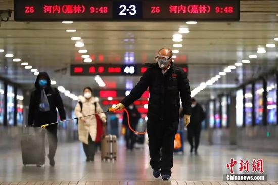 2月2日，工作人员在北京西站出站口进行消毒工作。中新社记者 富田 摄